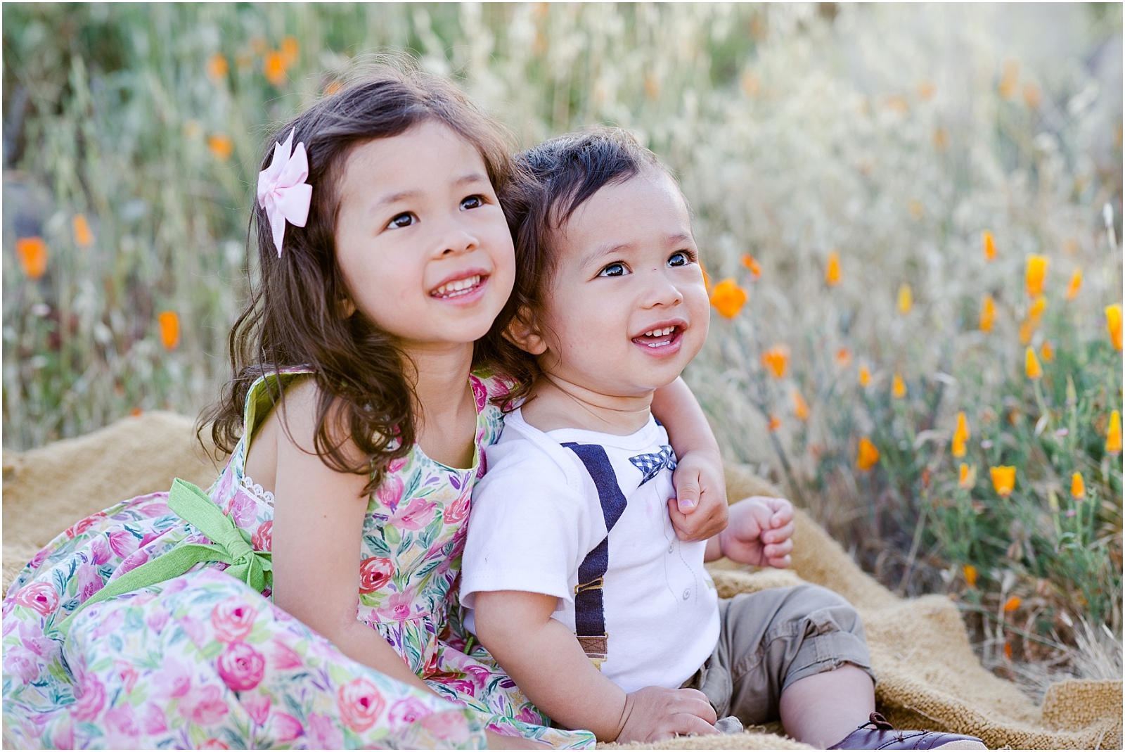 Two children smiling in a field of golden poppies in Livermore, CA