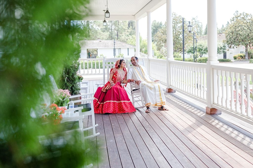 Indian bride and groom sitting in chairs on the deck at the Napa Silverado Resort, shot by Amber Rivas Photography