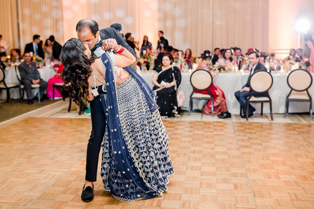 Groom dips and kisses the bride during their first dance at Indian wedding celebration at Napa Silverado Resort, shot by Amber Rivas Photography