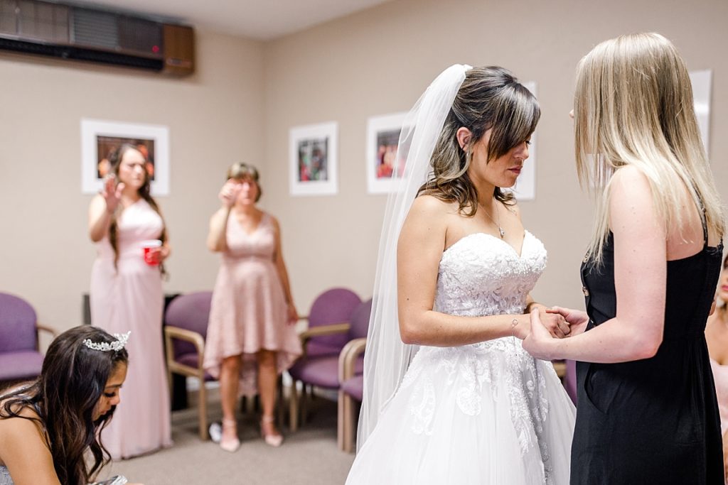 Bride praying with a friend before her wedding ceremony. Shot by Amber Rivas Photography.