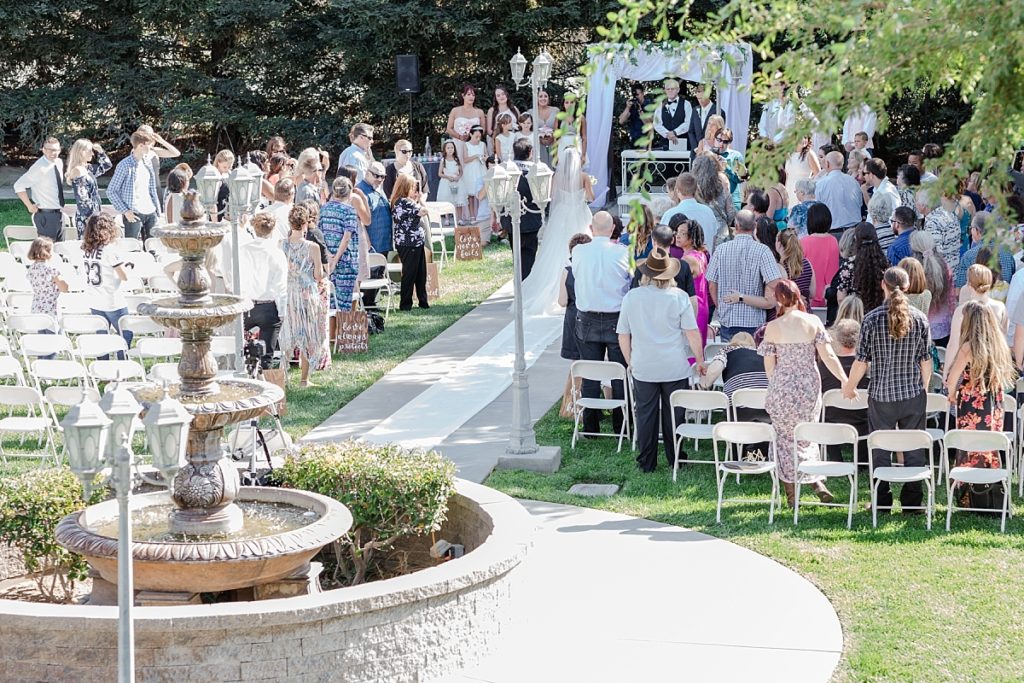 Aerial view of wedding ceremony in the church courtyard at Ceres Seventh-day Adventist Church. Shot by Amber Rivas Photography.