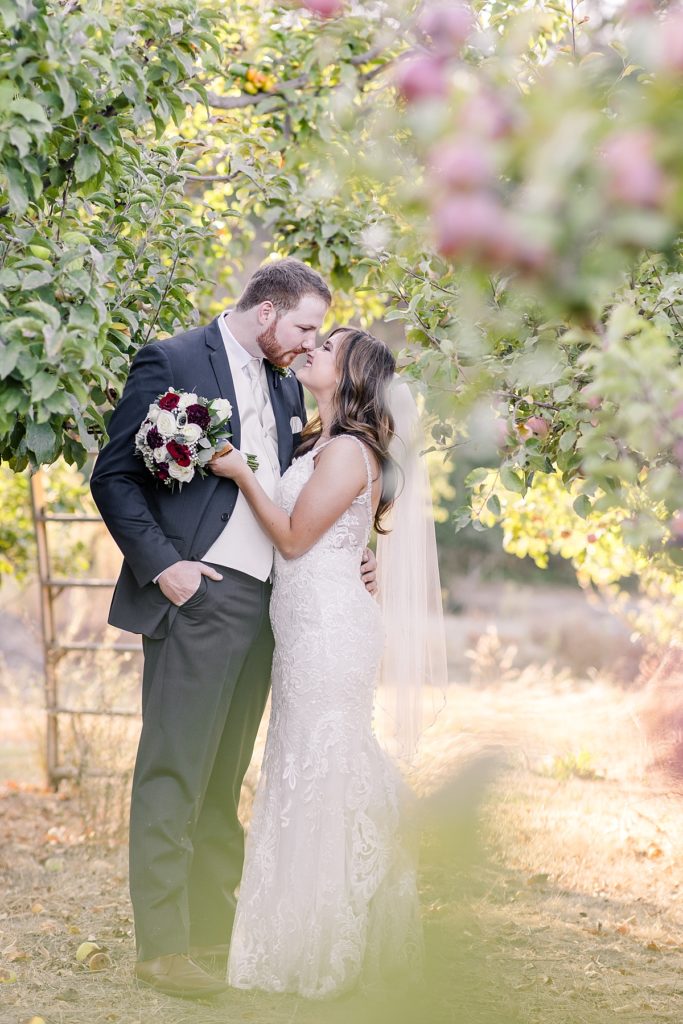 Bride and groom in the apple orchard during golden hour at The Orchard in Watsonville, CA. Shot by Amber Rivas Photography.