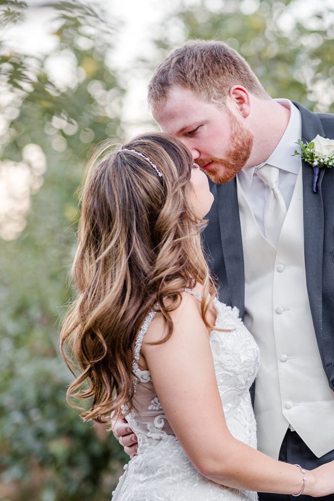 Bride and groom kissing in the apple orchard at their fall wedding at The Orchard in Watsonville, CA. Shot by Amber Rivas Photography.