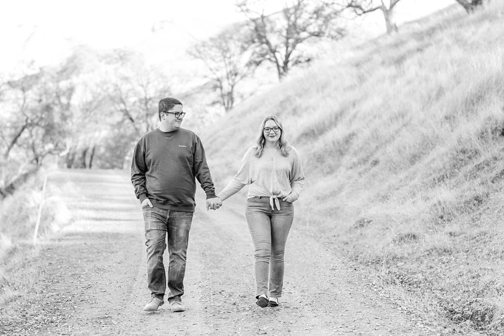 Black and white photo of couple walking down path at Del Valle.