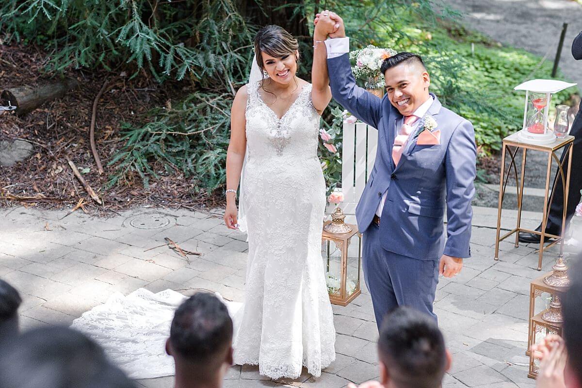 Newly married bride and groom holding hands at their Berkeley Botanical Garden ceremony