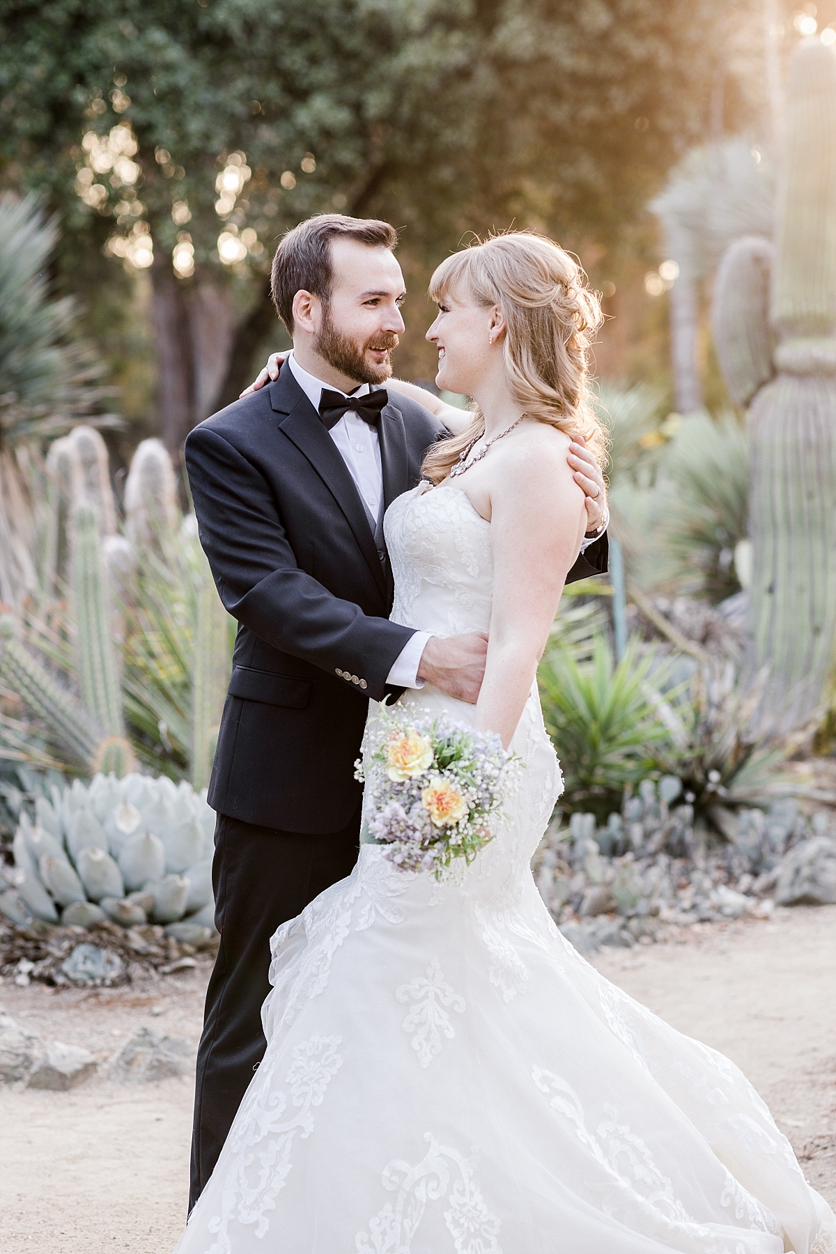 Arizona Cactus Garden styled shoot - bride and groom look into each others' eyes and smile.