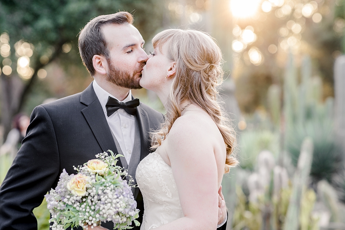 Bride and groom kiss during a styled shoot at the Arizona Cactus Garden.