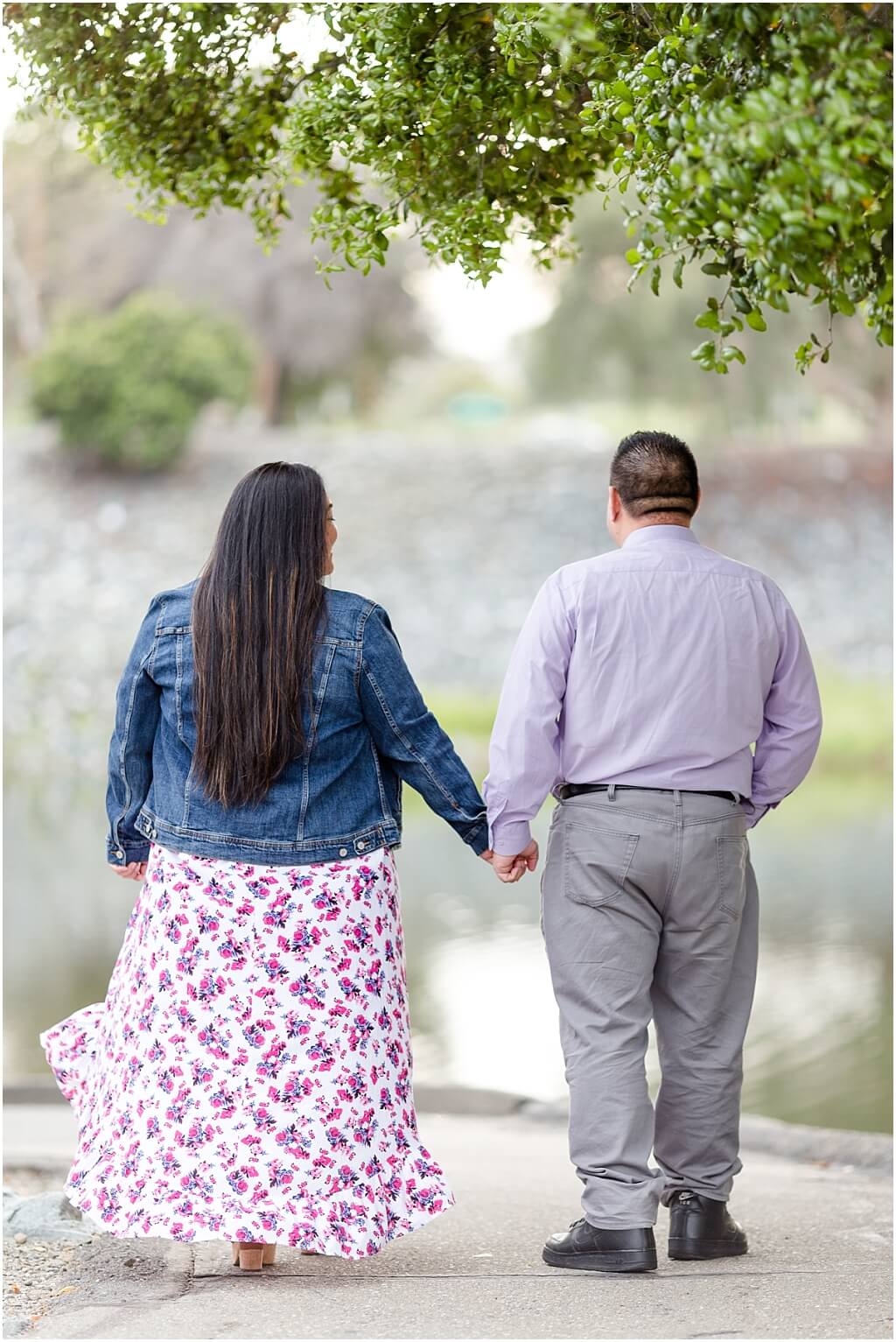 Couple holding hands walking away near the water at Niles Canyon