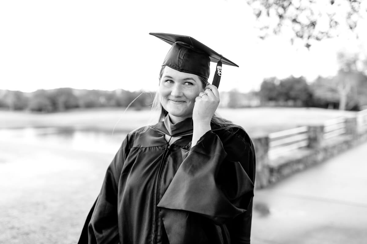 Black and white photo of woman in graduation gown with cap and tassel