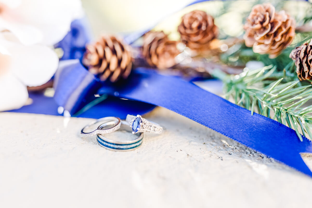 Blue groom's wedding band with bride's sapphire engagement ring.