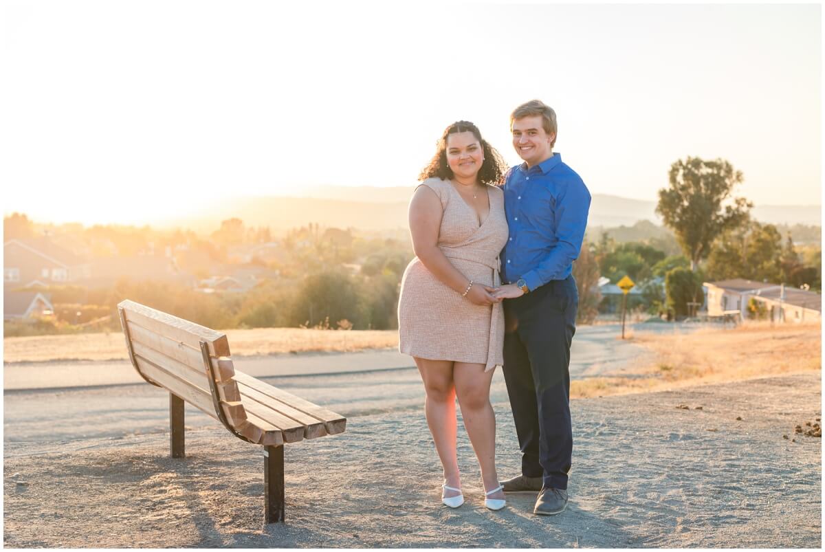 Couple holding hands at Holdener Park bench at sunset