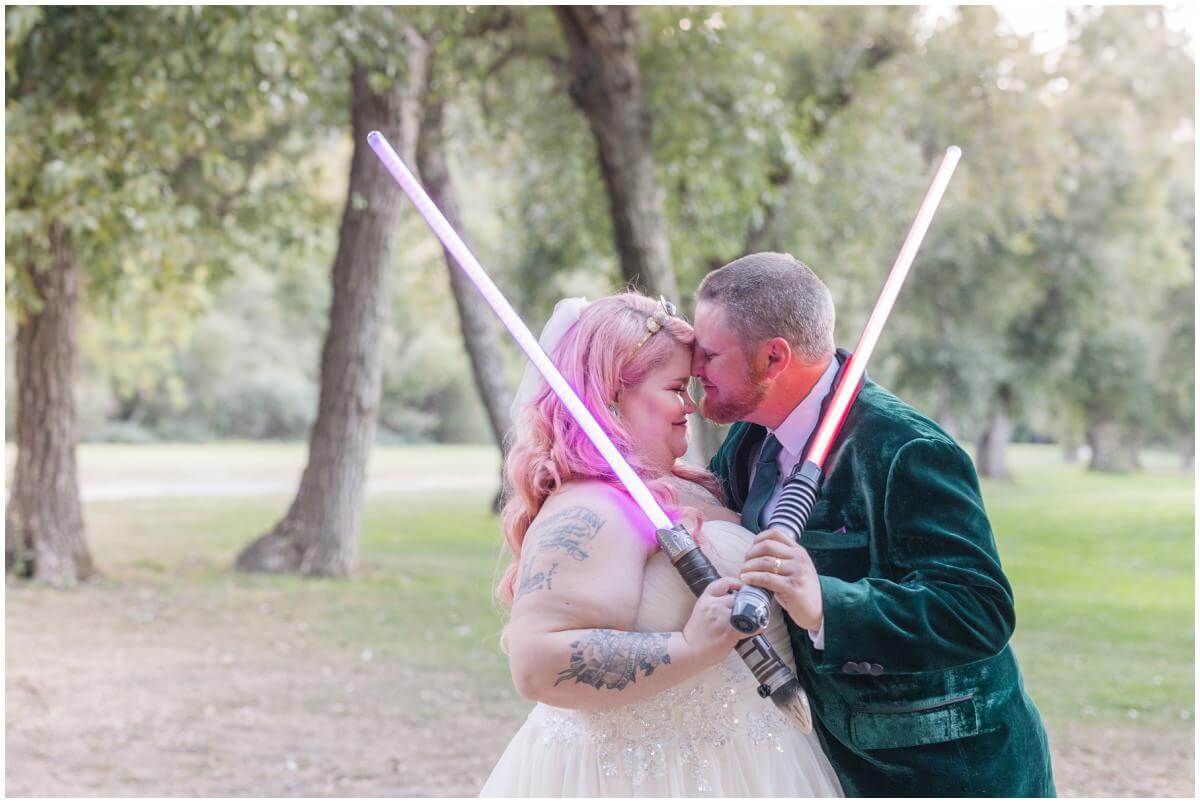 Bride and groom embracing with light sabers