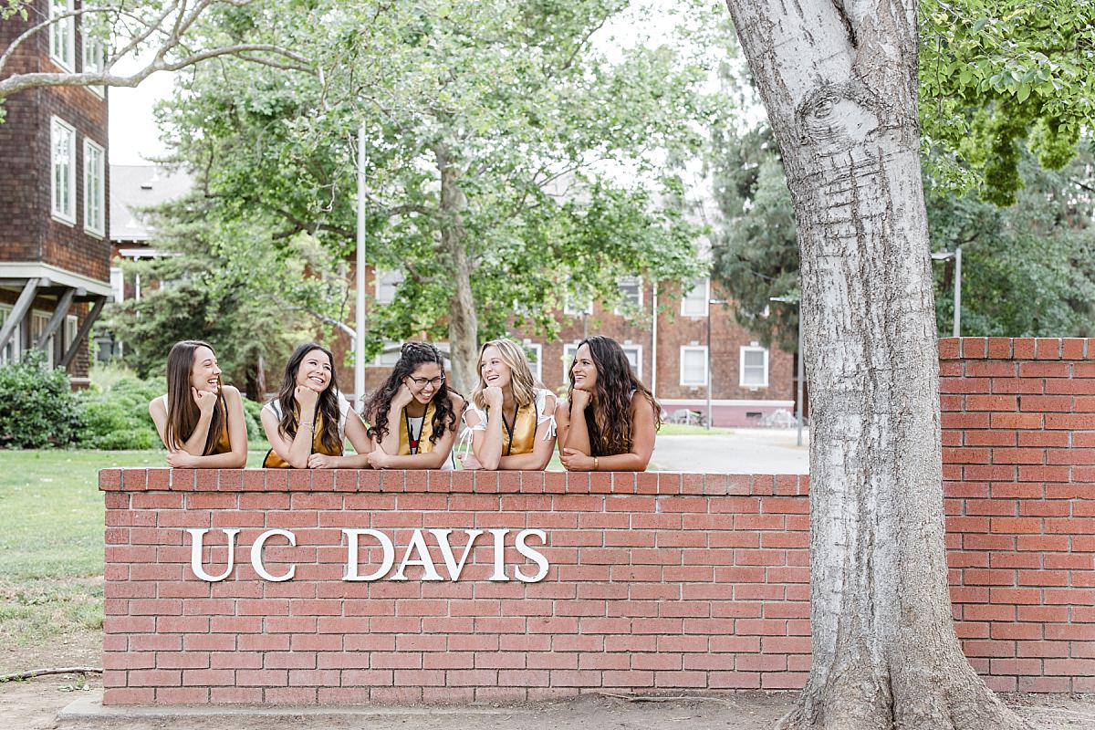UC Davis senior girls laughing at UCD sign
